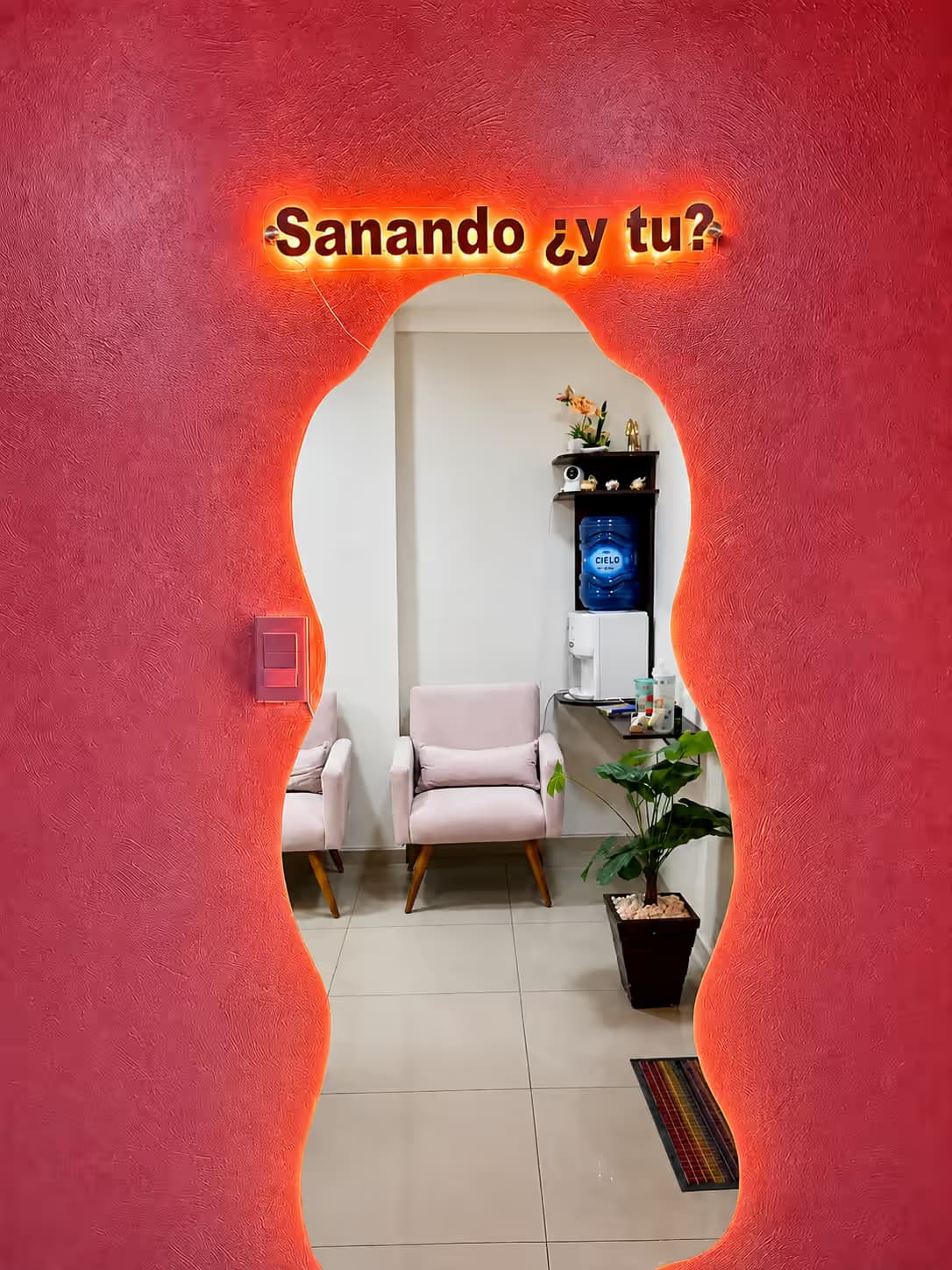Consultorio Oficina 211 — espejo con el mensaje «Sanando ¿y tú?» en neón