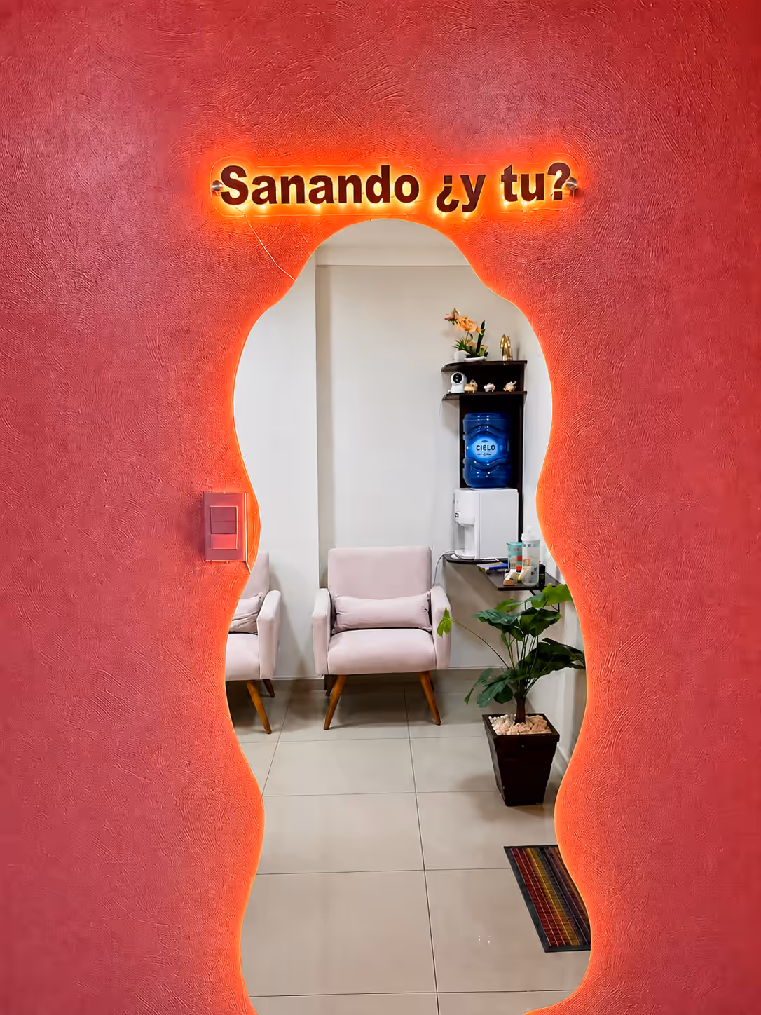 Consultorio Oficina 211 — espejo con el mensaje «Sanando ¿y tú?» en neón